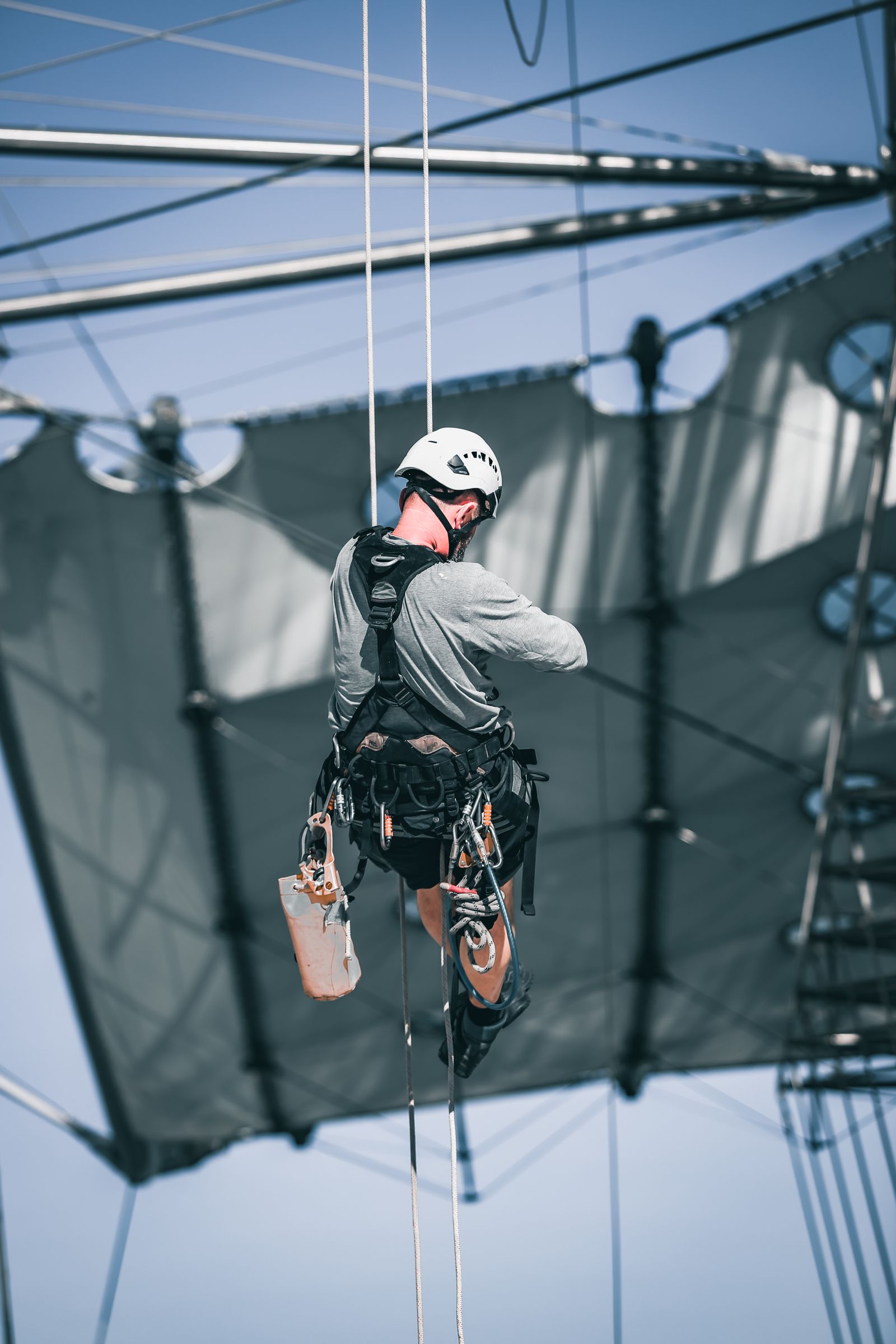 Worker in a full fall-protection harness at height